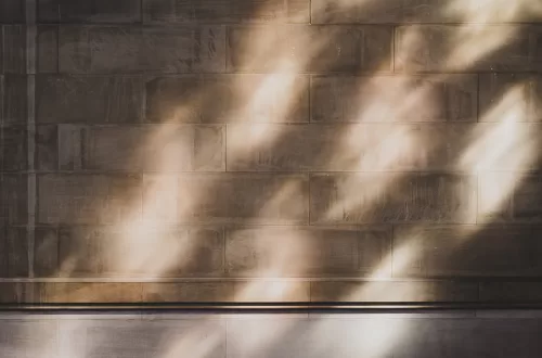 Asian couple kissing in a light-filled room with sunlight through the window against the cobblestone wall