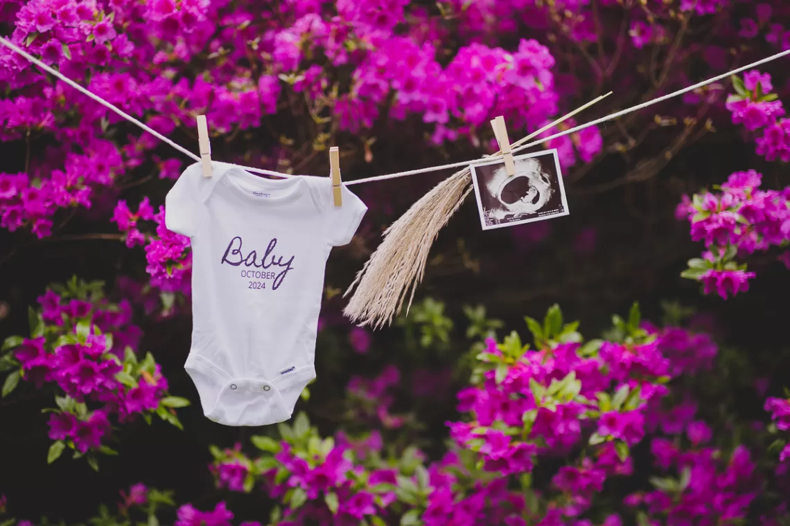 Gender Reveal decor with a baby onesie. a sonogram hung on a clothsline