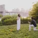 Couple proposing in the park with the Brooklyn Bridge in the background