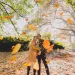 Interracial couple throw autumn leaves in the air in Fort Greene Park